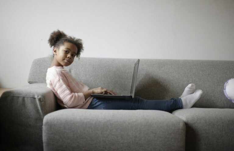 Child on a sofa with a computer