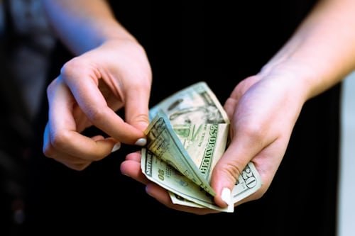 Hands of woman counting money